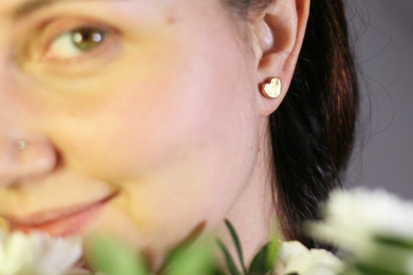 Coppia di orecchini cuore indossati. Orecchini fatti a mano in ceramica e lustro oro.