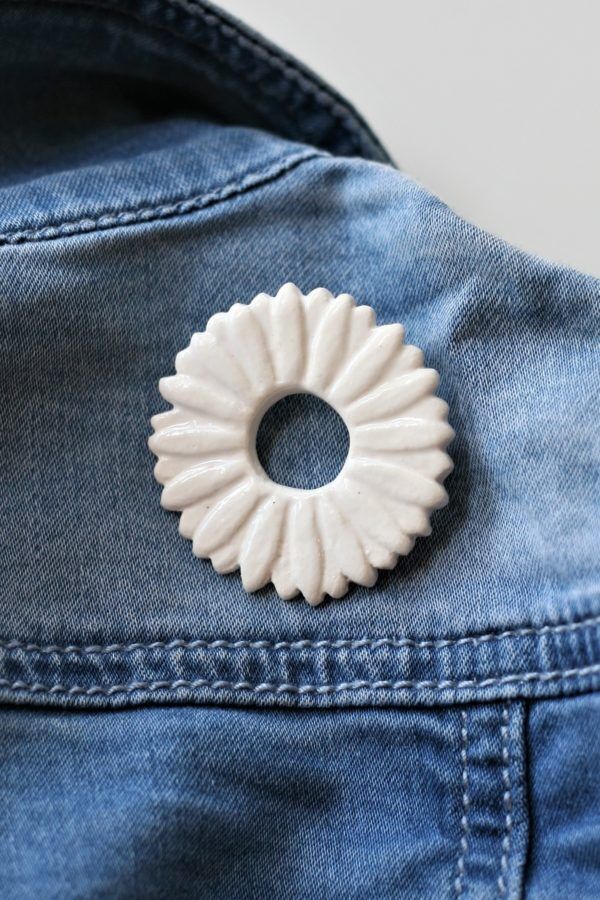 immagine di spila corolla in ceramica bianca su jeans blu